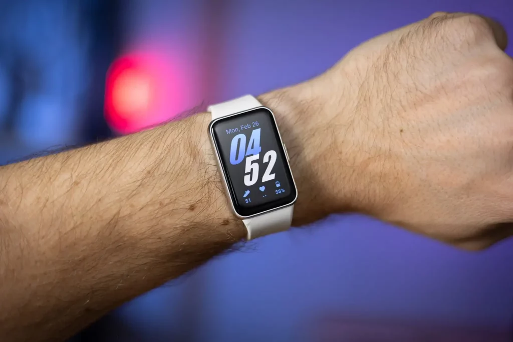 گلکسی فیت ۳ با بند سفید روی مچ دست مردانه و با نمایشگر روشن