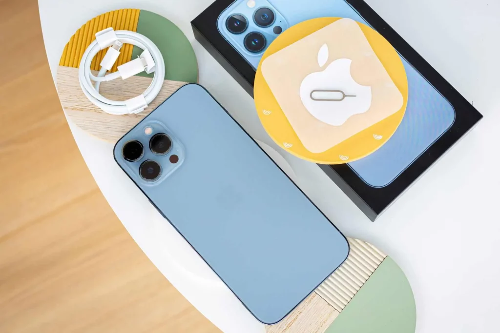 آیفون ۱۶ پرومکس آبی درکنار جعبه و کابل تایپ سی